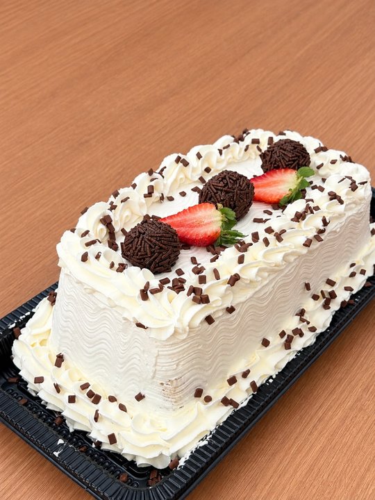Torta confeitada com chantilly, brigadeiros e morangos